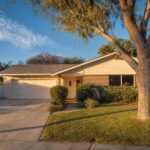 Single-story ranch home with updated exterior, mature pepper tree, and wide driveway in Old Granada Hills.